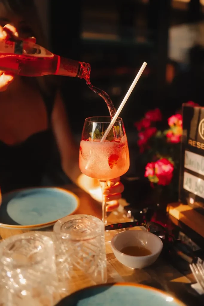 Cocktail préparé avec du gin acolyte ainsi qu'avec un tonic rouge, glaçons et des morceaux de fruits rouges.